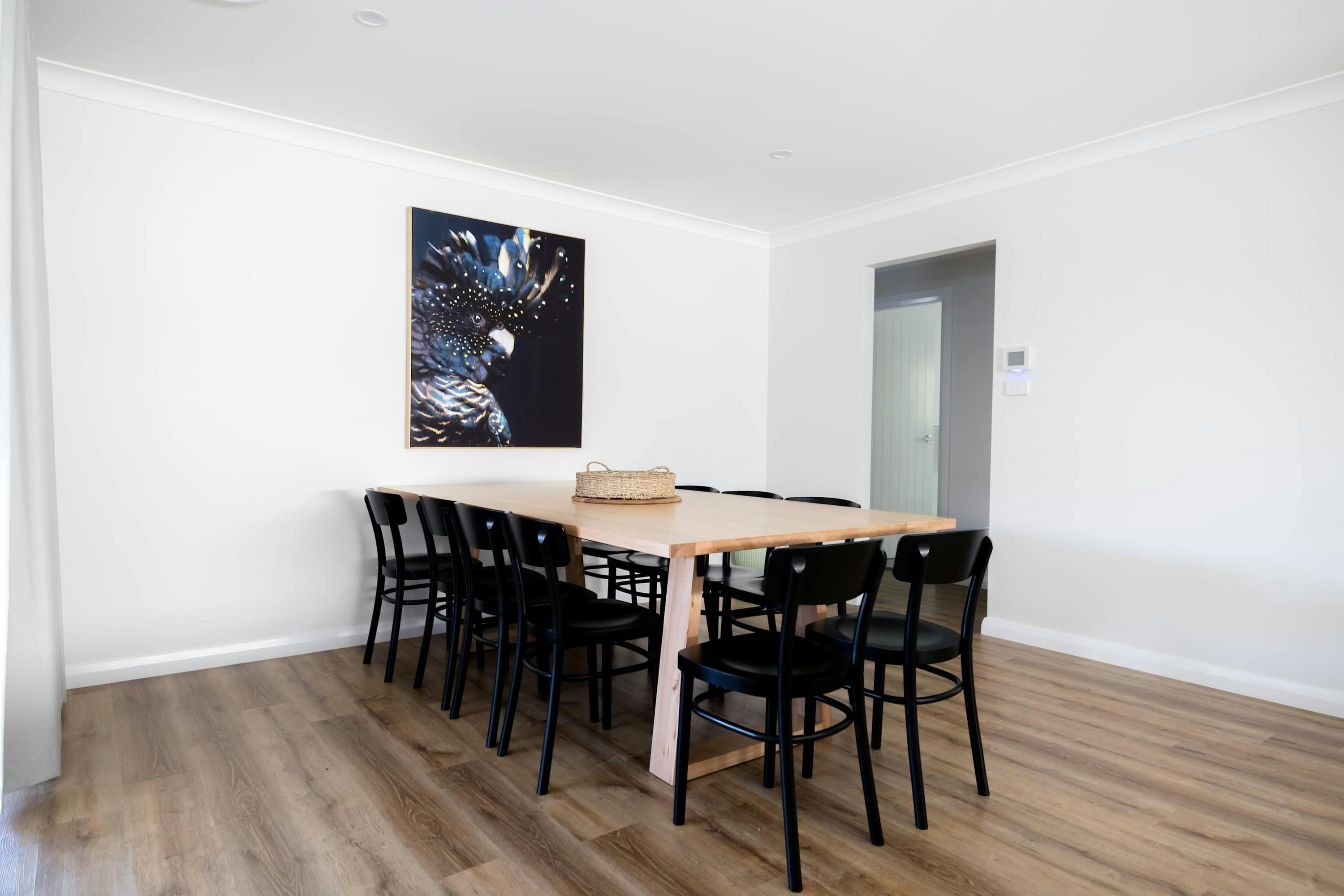 Dining table with 10 black dining chairs around the wooden table.