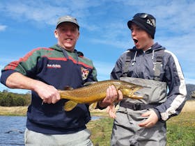 A happy client and his son showing of a 28 Gates fish