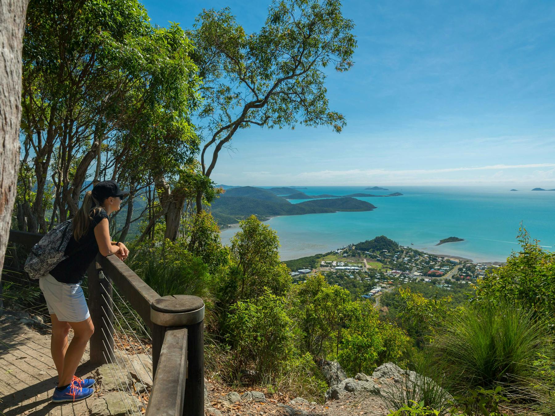 Person standing at lookout enjoy views of the blue ocean speckled with islands