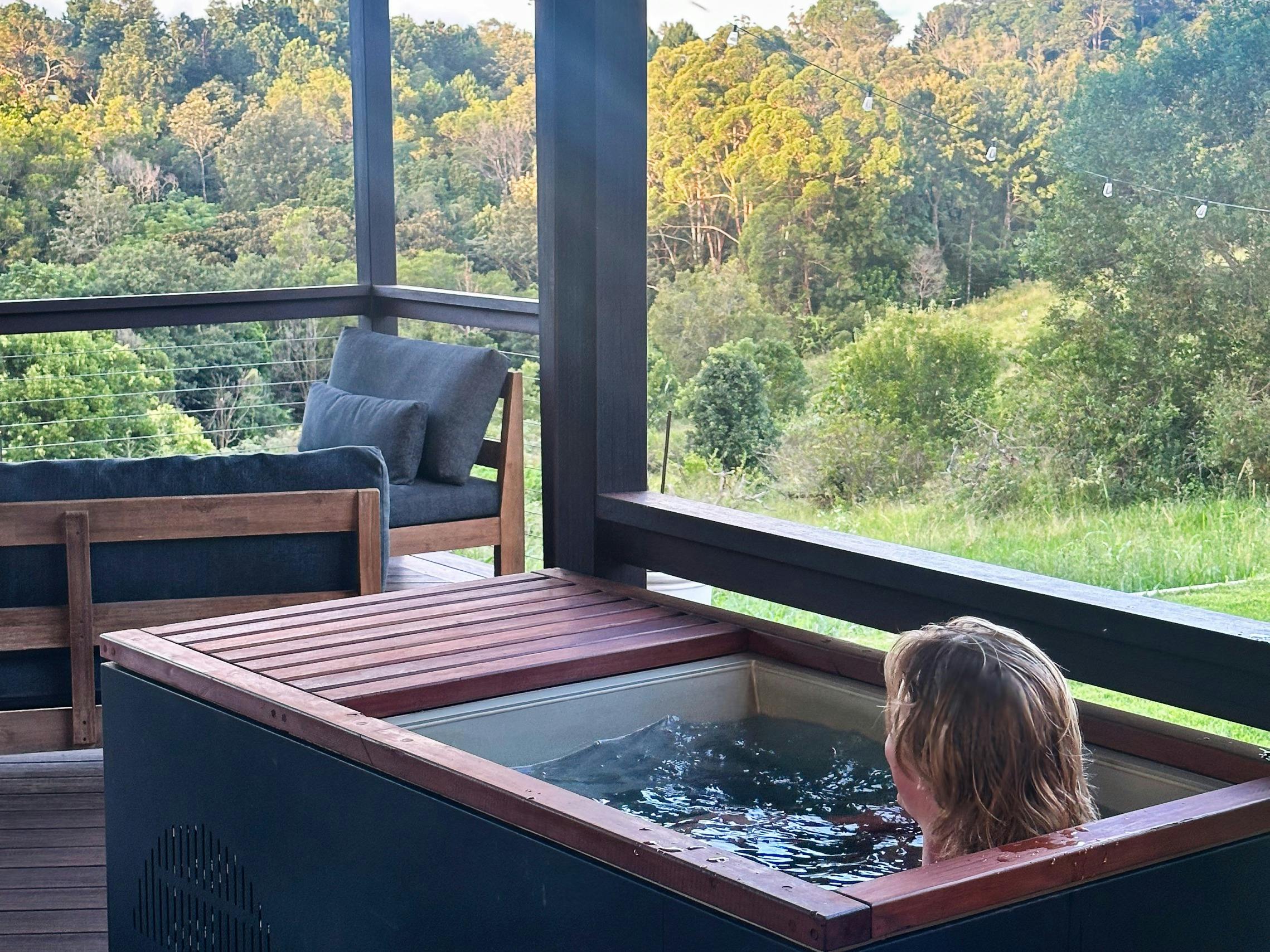 Man relaxing in cold plunge looking out to scenic view at The Range Holistic Spa, Montville
