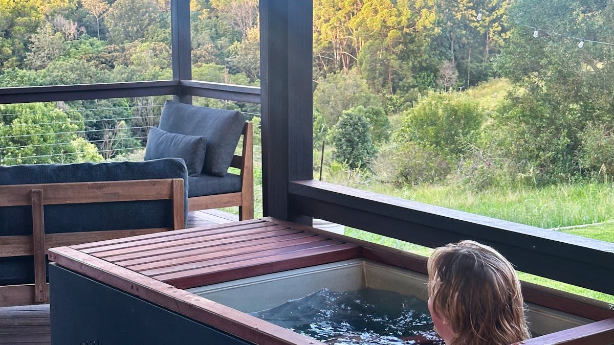 Man relaxing in cold plunge looking out to scenic view at The Range Holistic Spa, Montville