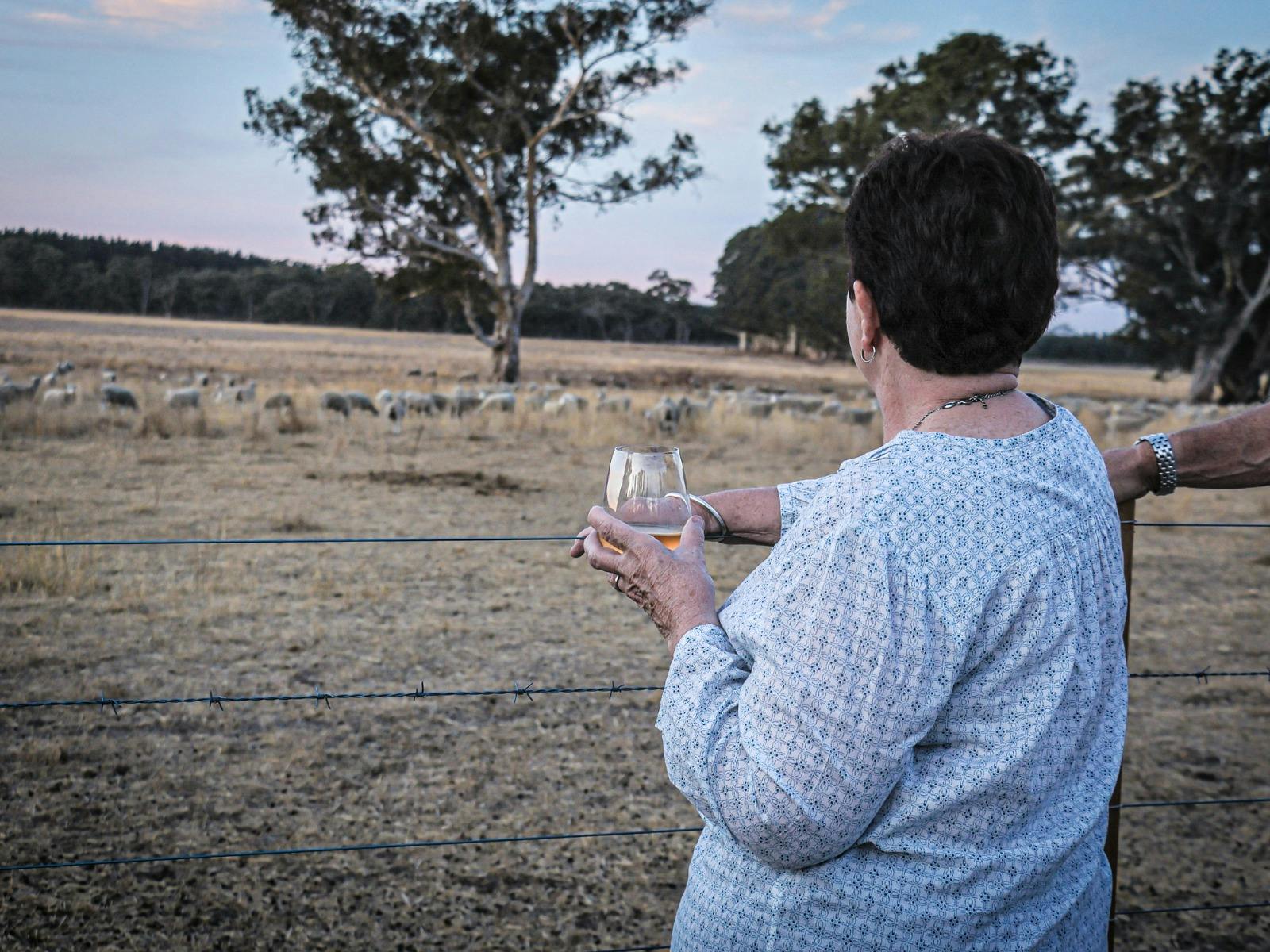 Guest enjoying a glass of wine whilst taking in the view of the farm