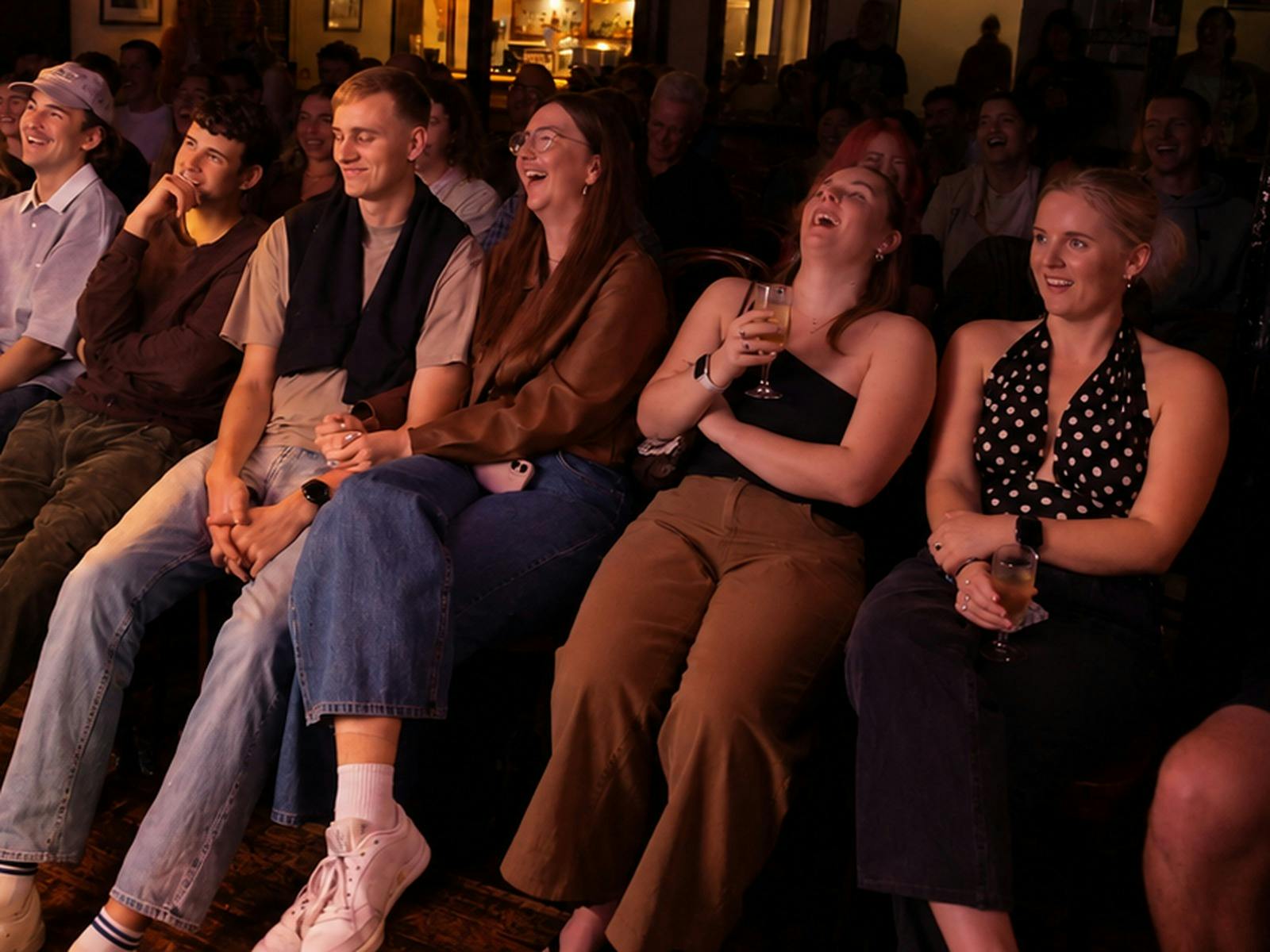 Audience members laughing and holding drinks at a stand-up comedy show at the Royal Hotel Darlington