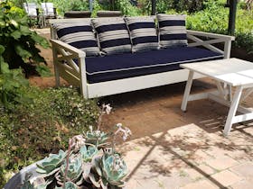 Relax under the rose cover pergola on the sofa bed overlooking the garden