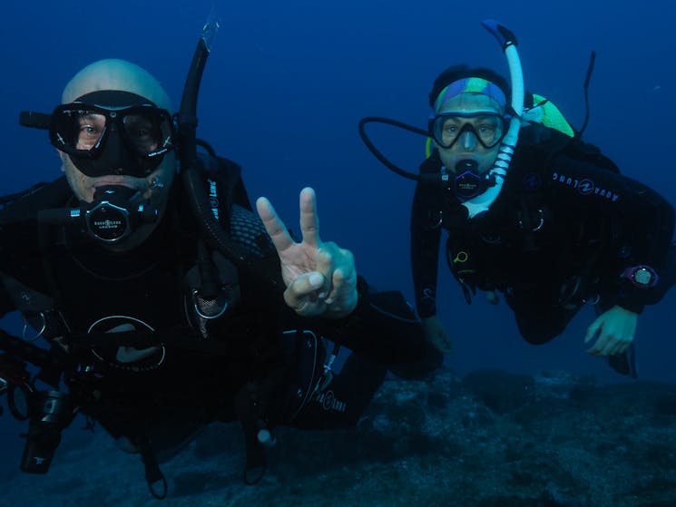 Two divers underwater wearing scuba equipment.