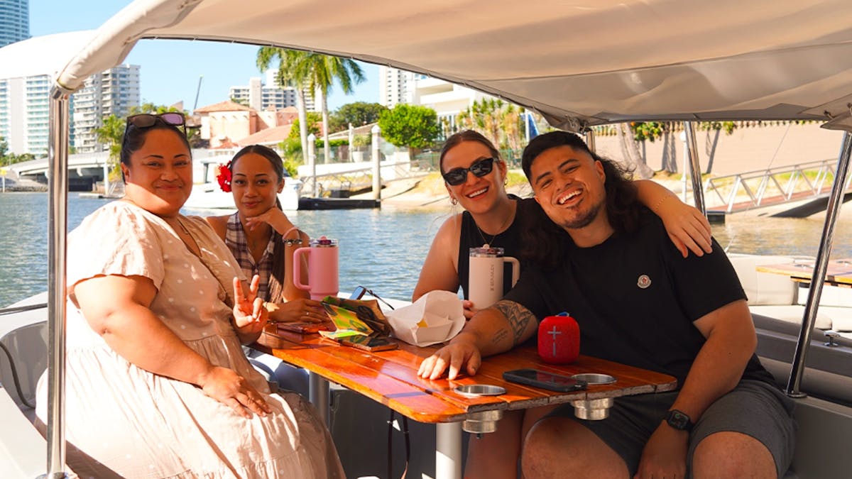 Friends sharing a picnic and drinks aboard a self-drive GoBoat on the Gold Coast.