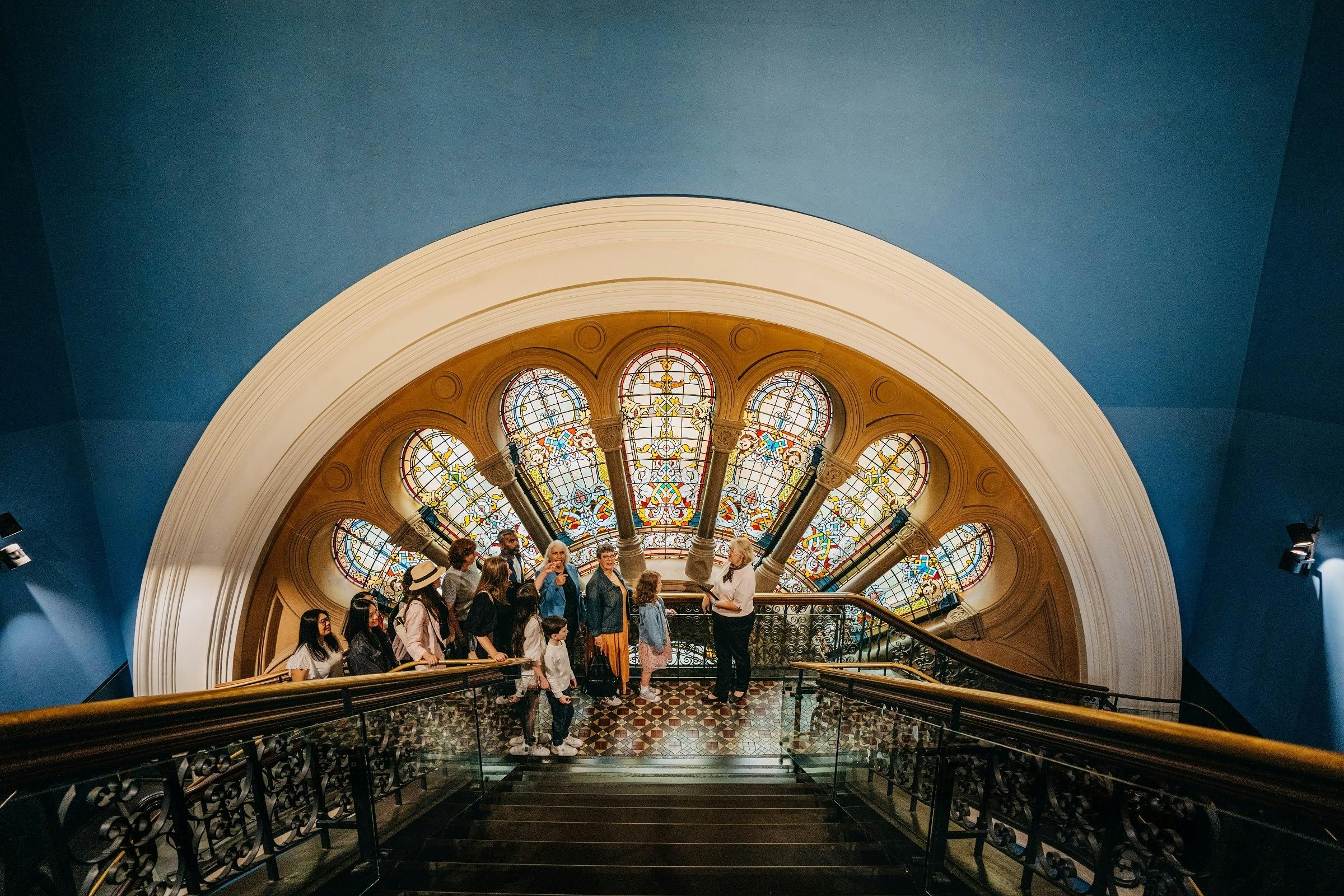 A QVB History Tour group stopping at one of the stained glass windows