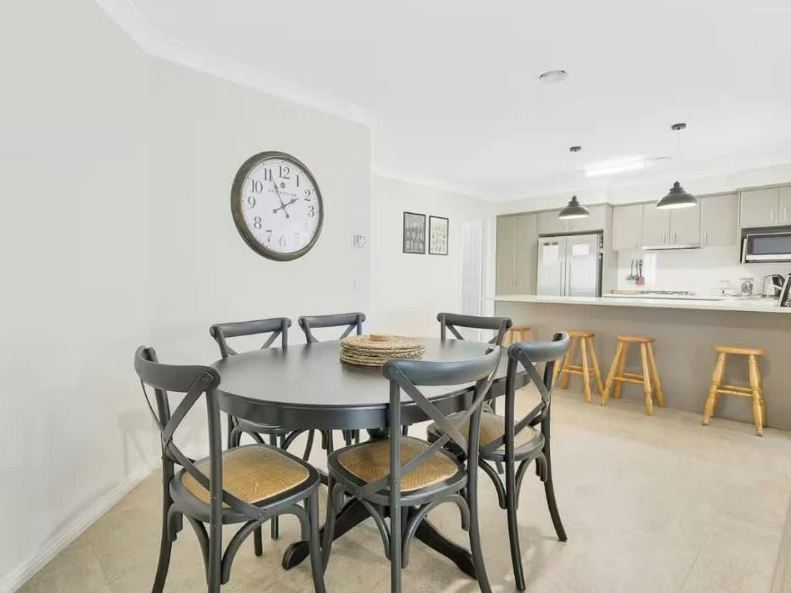 Dining room with round table and dining chairs, between kitchen and lounge area
