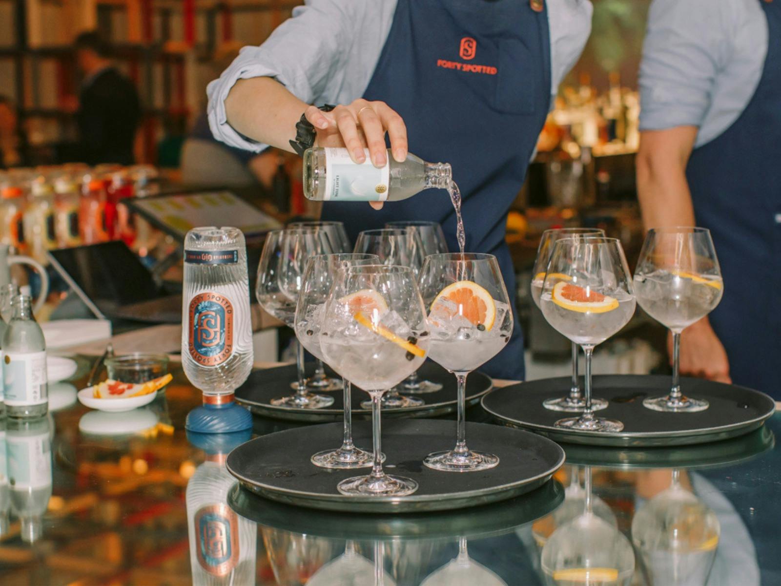 Bartender topping up glasses of Forty Spotted Gin with Tonic to be served