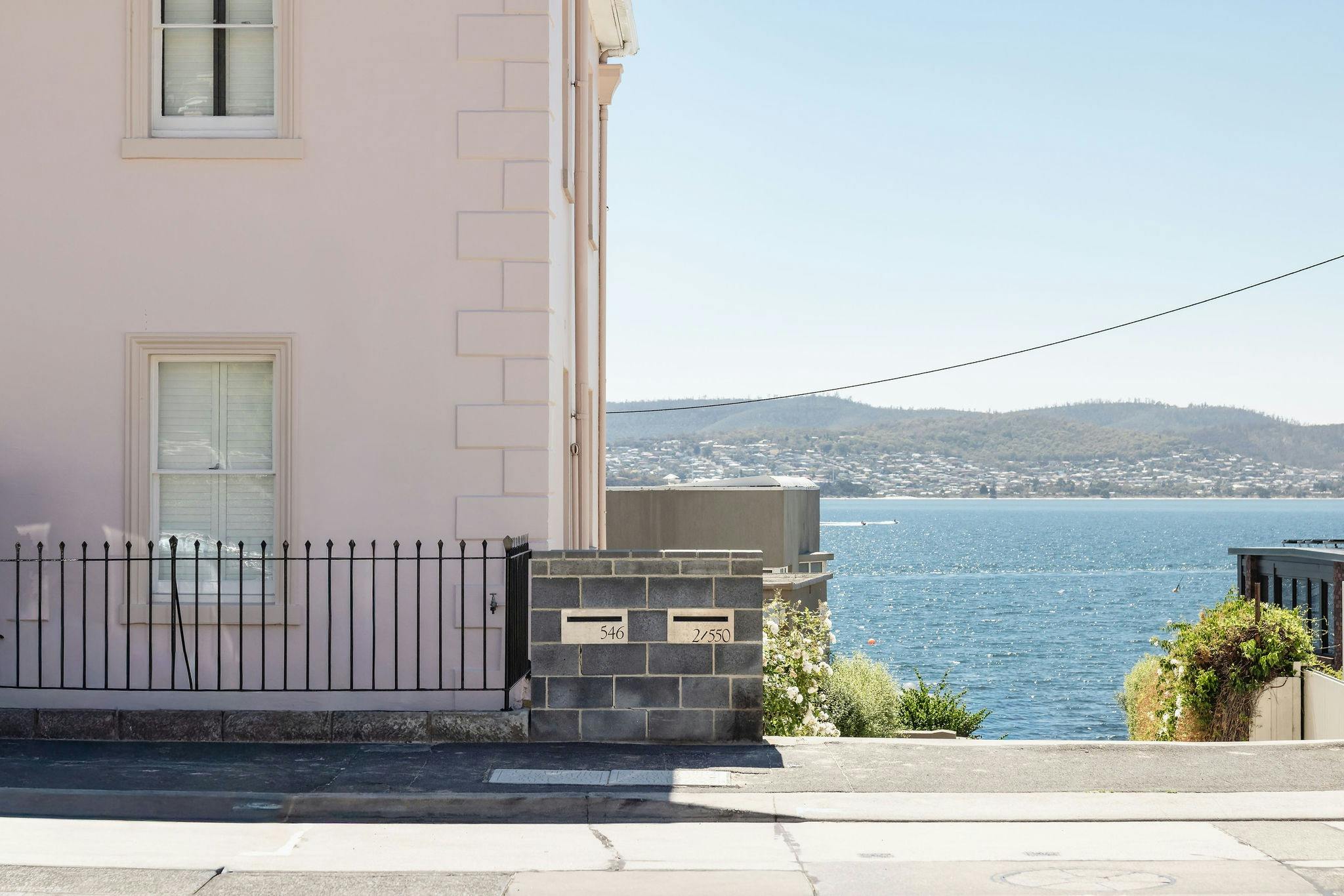 An image capturing the facade and sea view from the driveway of Maison Del Mar in Sany Bay Hobart
