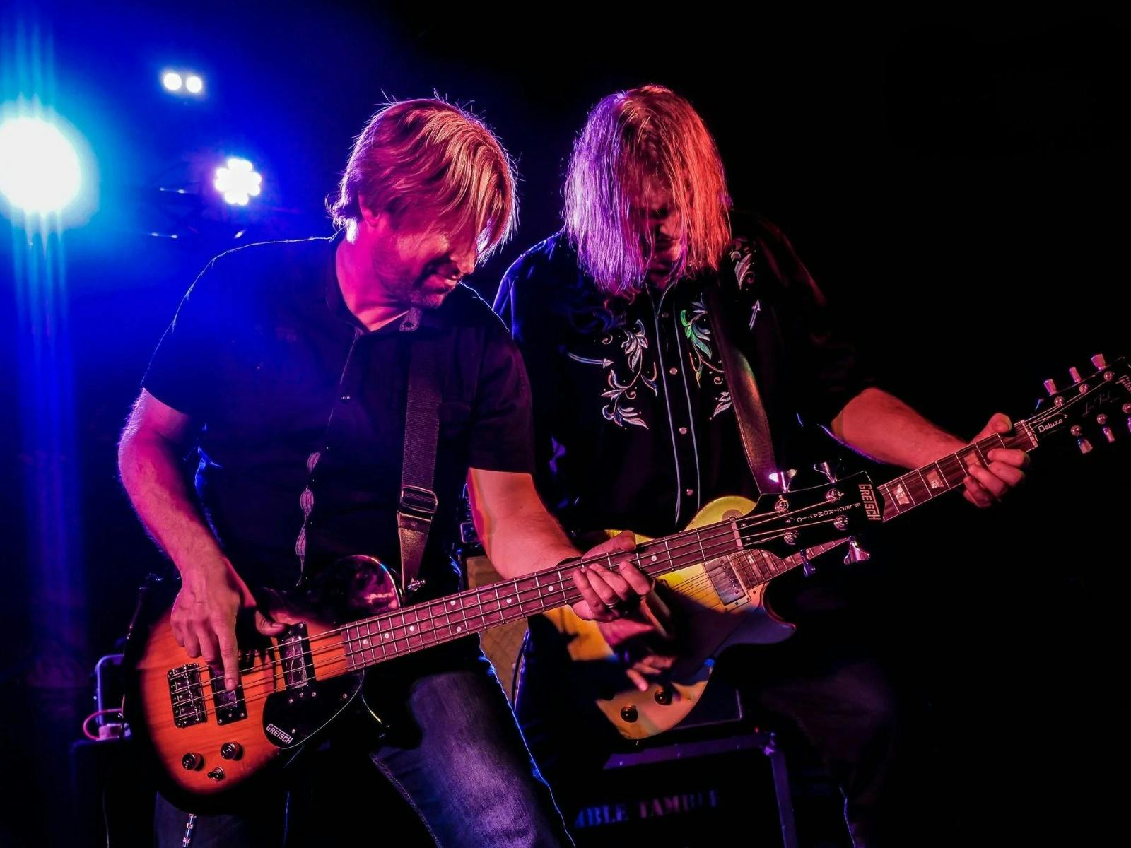 2 man performing, both playing guitar