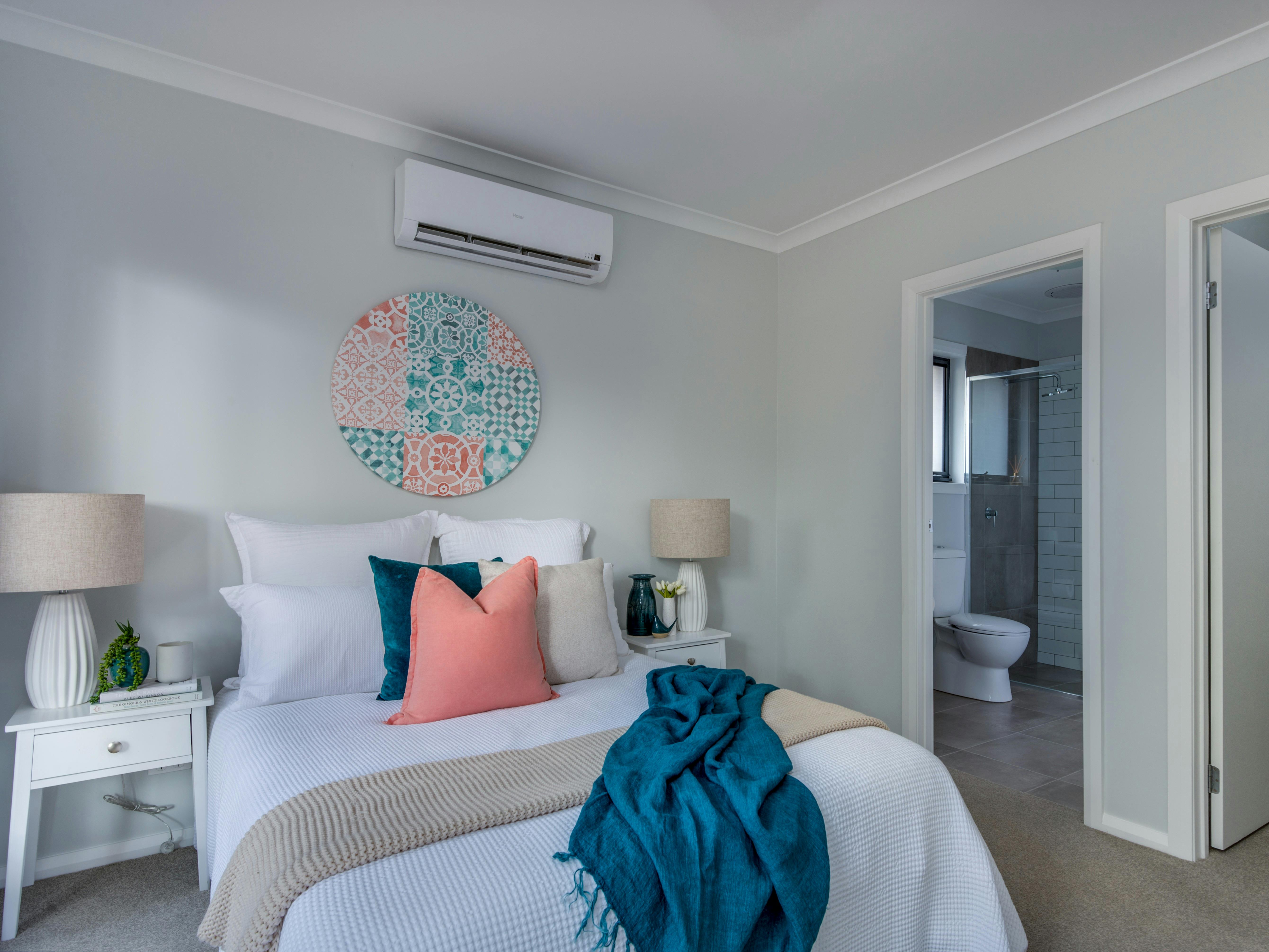 Room with a bed, split system and entrance to the ensuite