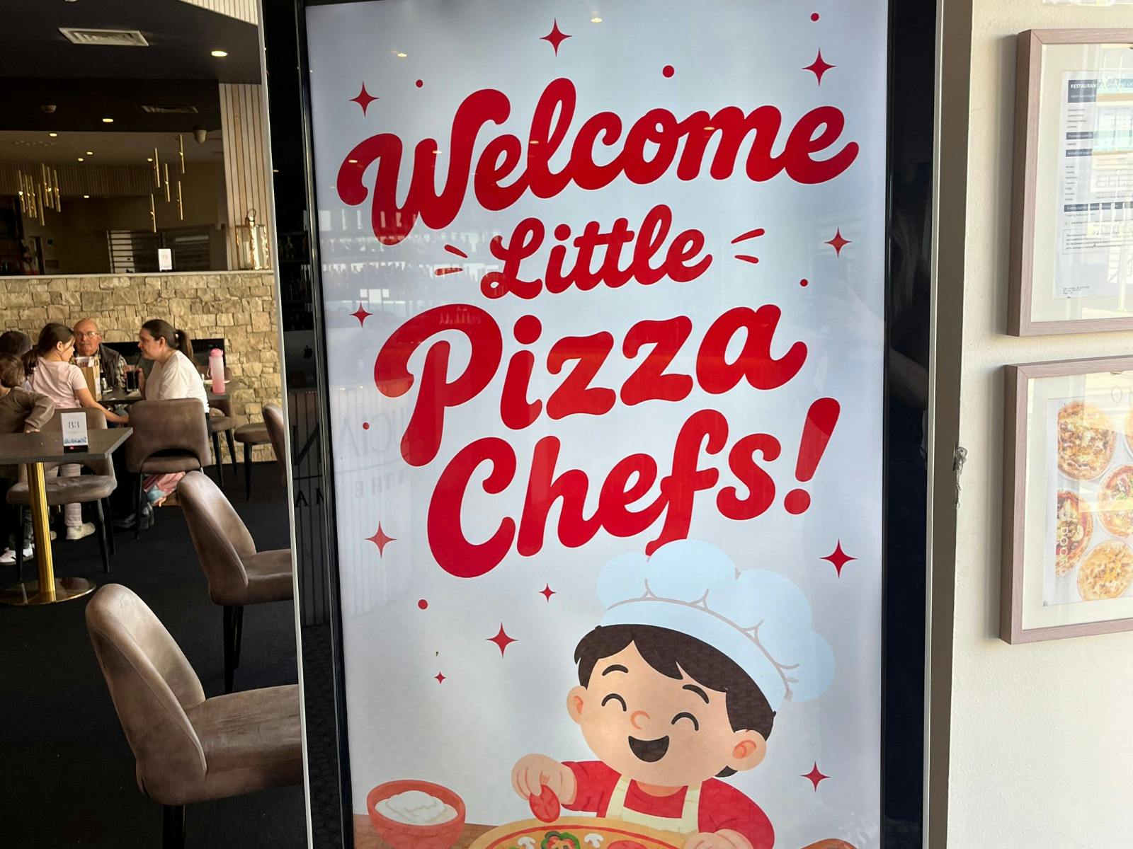 A digital welcome sign screen that says Welcome Little Pizza Chefs