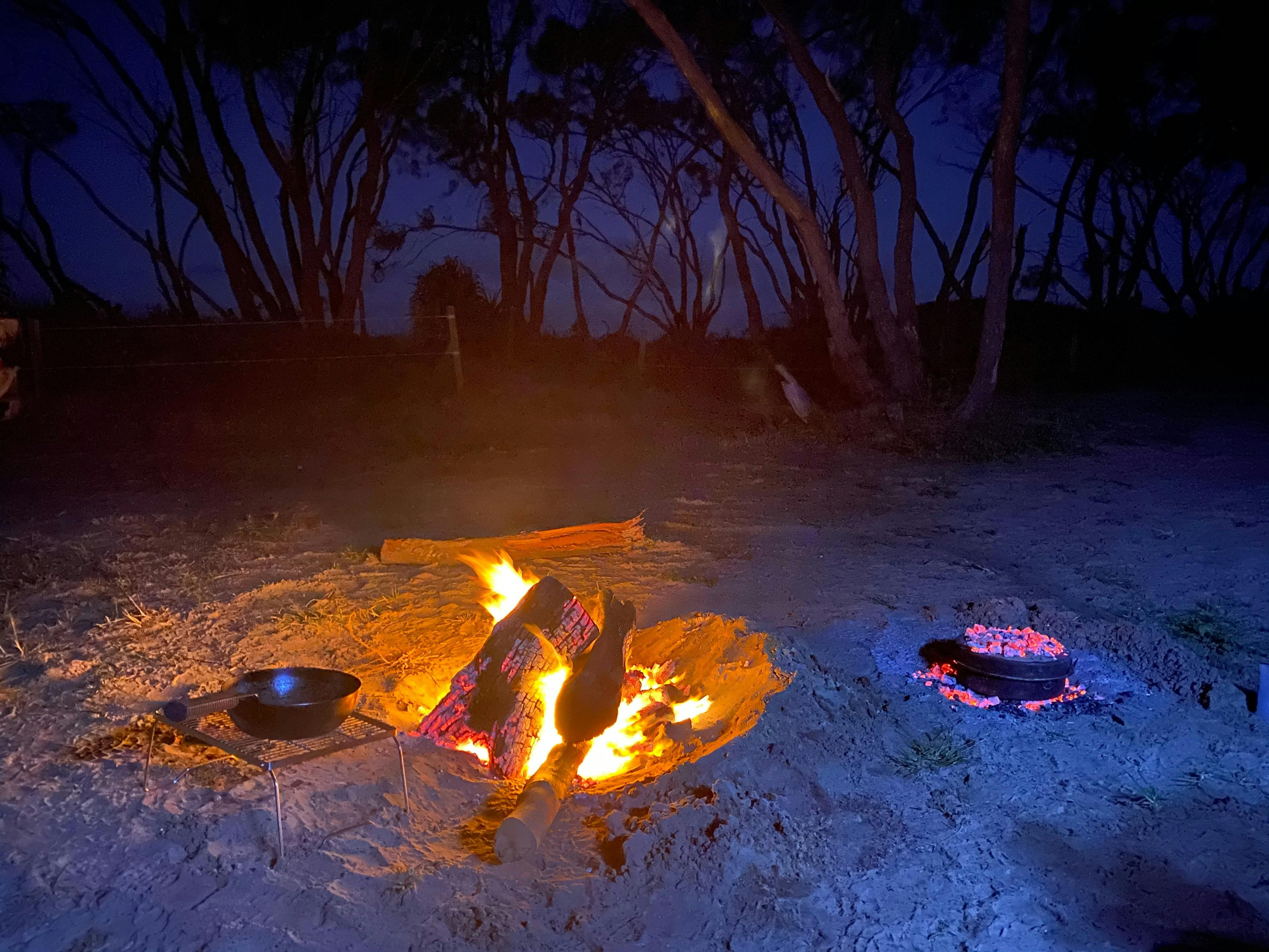Cooking fire with small coal pit next to it with a camp oven. Inside is mums lamb roast!