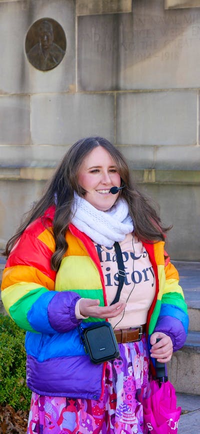 Tour guide Millie wearing a rainbow puffer jacket and headset