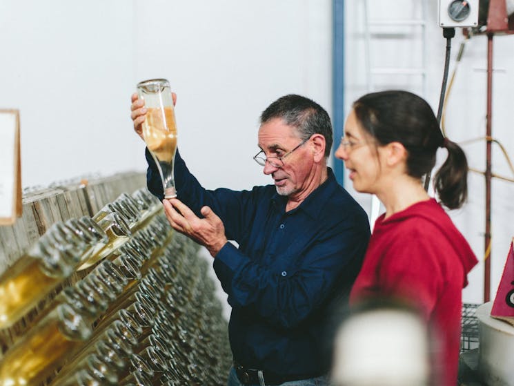 Howard & Christobelle checking a bottle of sparkling wine