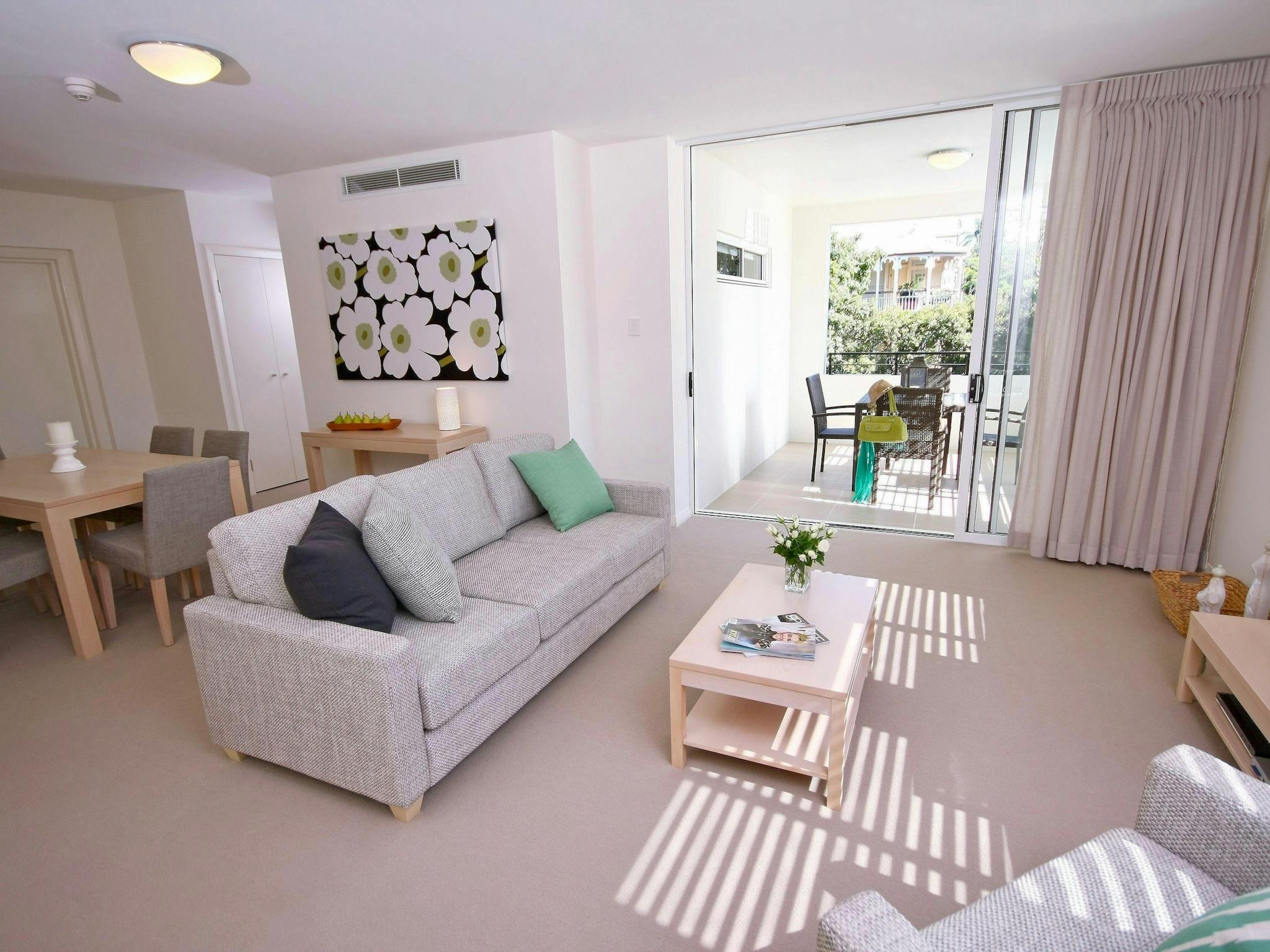 Sun-filled living room with balcony access at Domain Serviced Apartments Ascot Sun-filled living room with balcony access at Domain Serviced Apartments Ascot