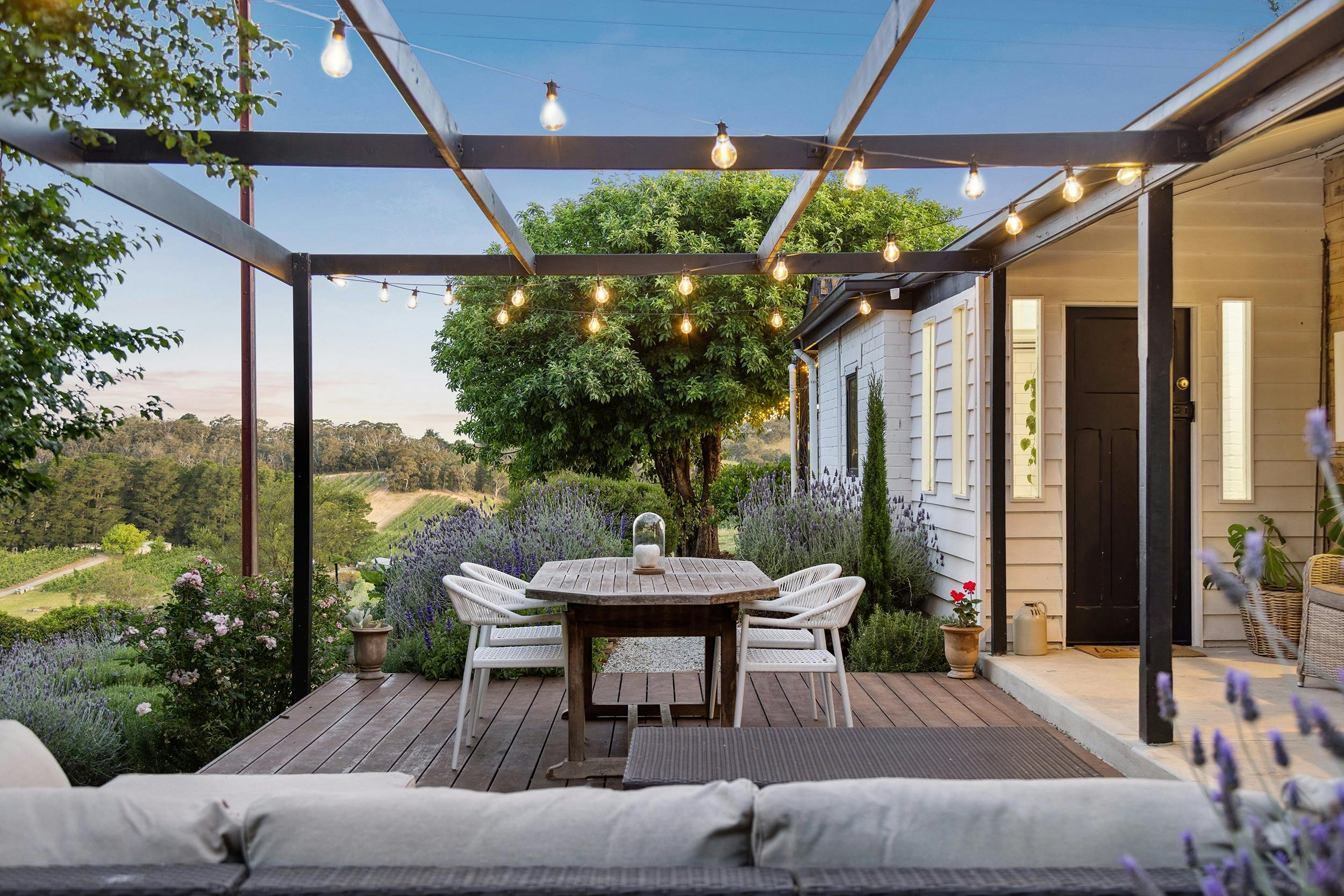 Outdoor deck with comfy wrap around couch and festoon lighting