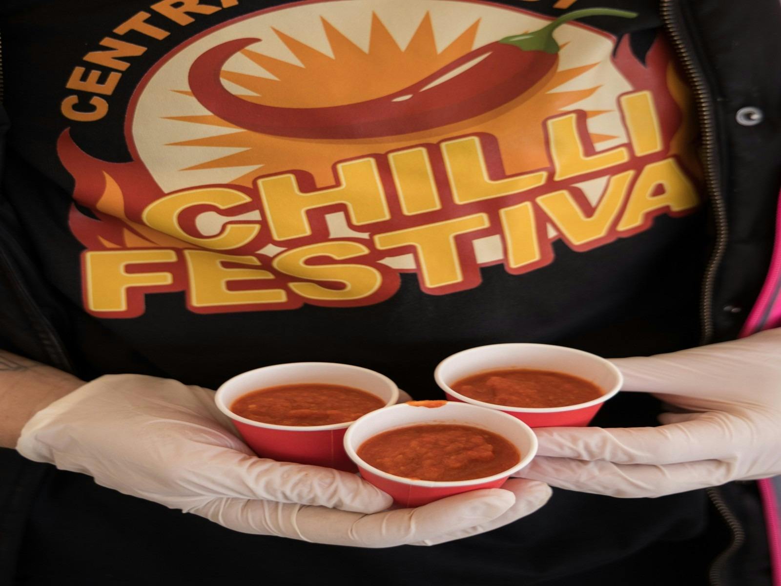 Festival staff serving chilli samples during a chilli food festival.