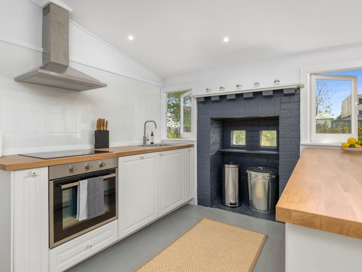 kitchen with oven, rangehood. White grey and timber decor.