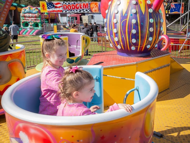 Children sitting in the Teacup ride - Carnival component of the Airshow