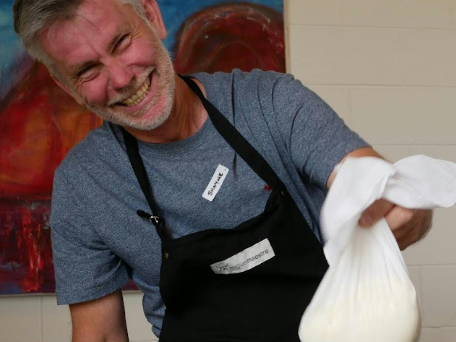 Holding up the cheese to let the whey drain while making cheese