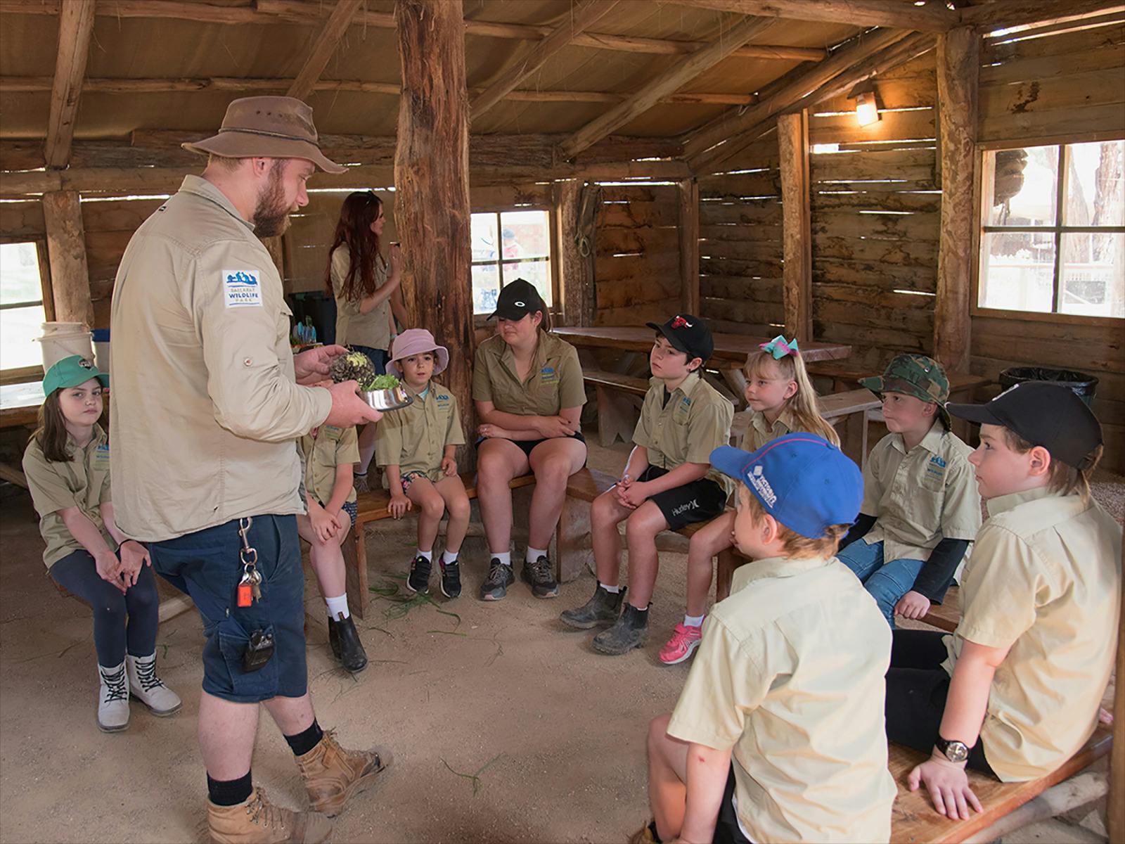 Zoo keeper and children preparing animal food