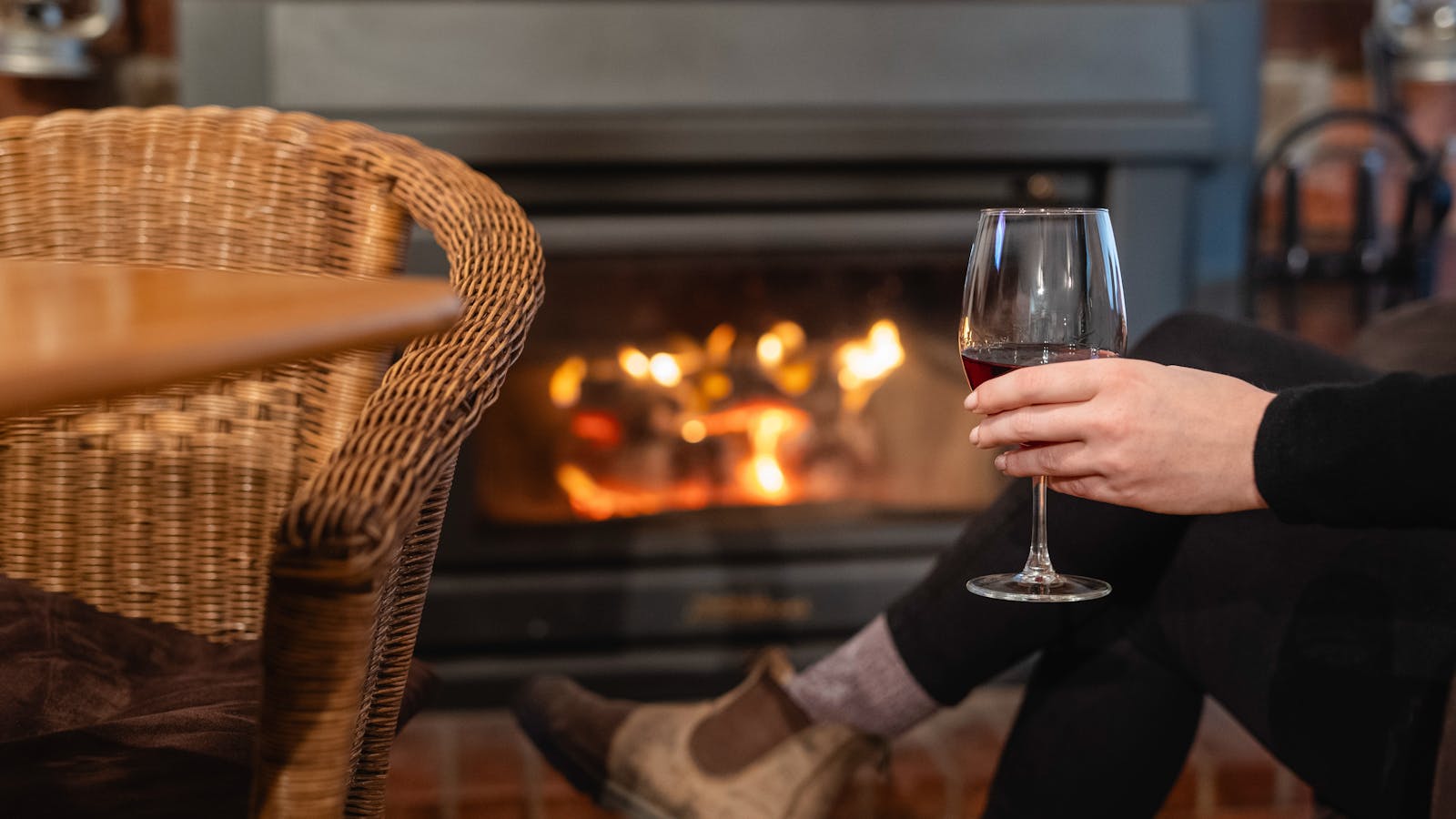 Relax with a warm fire and a glass of wine at Maydena Eats, perfect for a cozy evening.