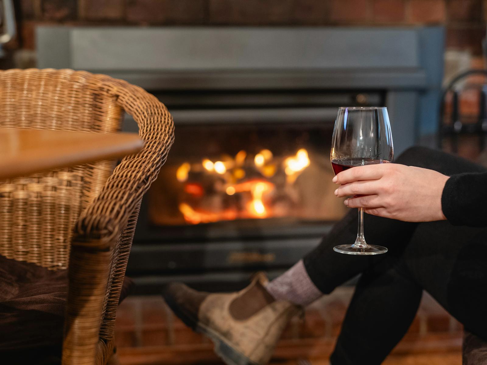 Relax with a warm fire and a glass of wine at Maydena Eats, perfect for a cozy evening.