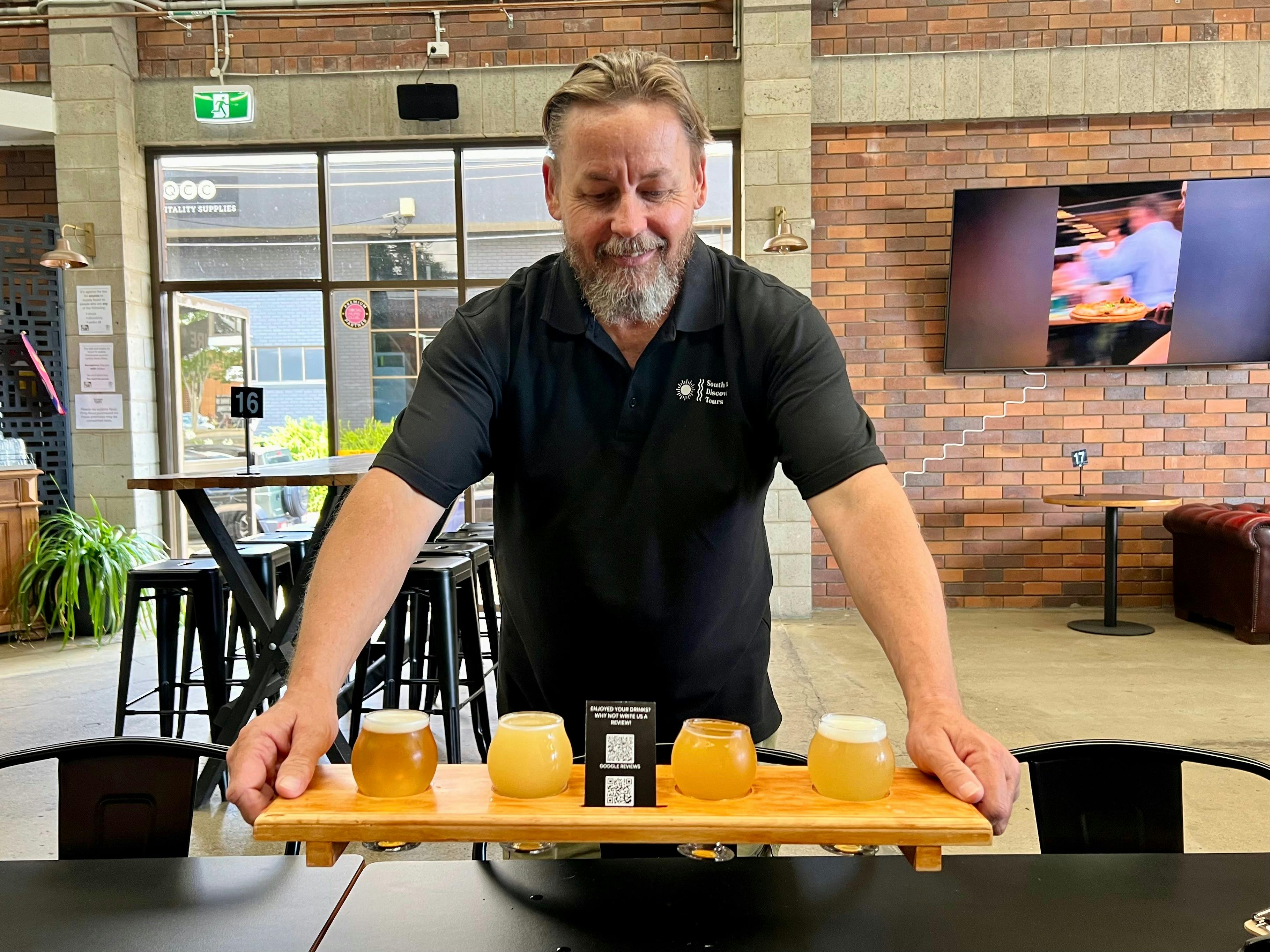 South East Discovery Tours' host, PJ, presenting a tasting paddle at Future Magic Brewing Co.