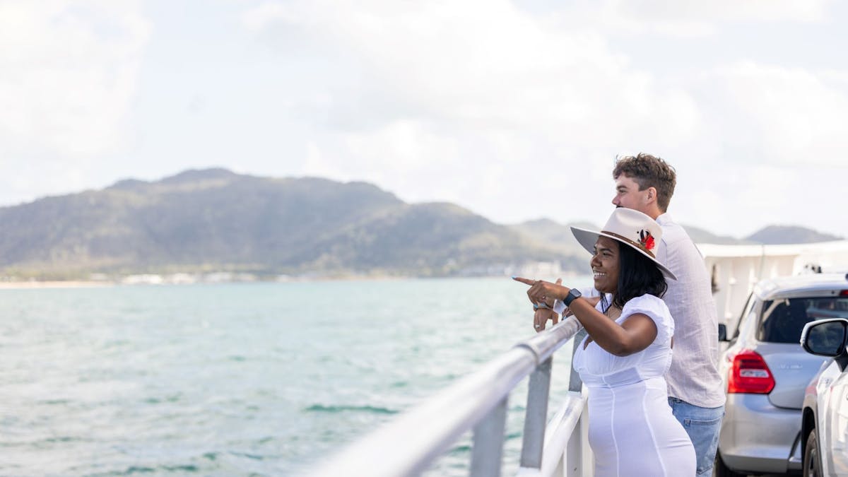Two passengers standing on the vehicle deck of Magnetic Island Ferries looking toward Magnetic Two passengers standing on the vehicle deck of Magnetic Island Ferries looking toward Magnetic