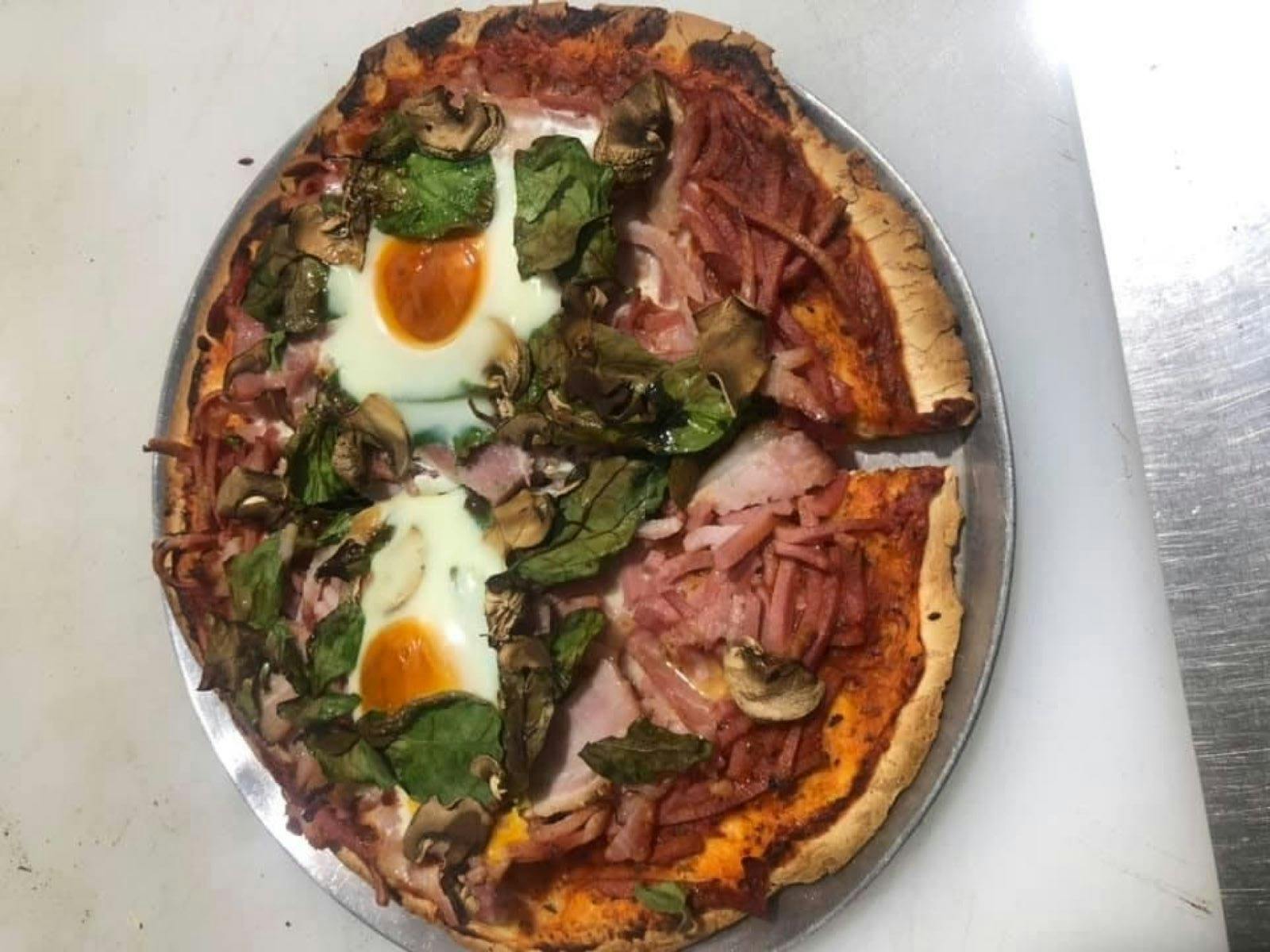 Mumma J's Breakfast Pizza with egg, spinach, bacon and mushrooms on a tin cooking tray