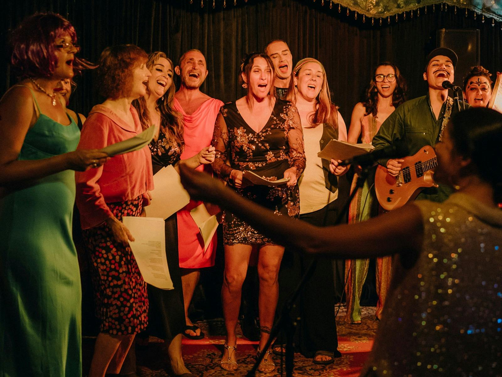 A group of colourfully dressed people singing together