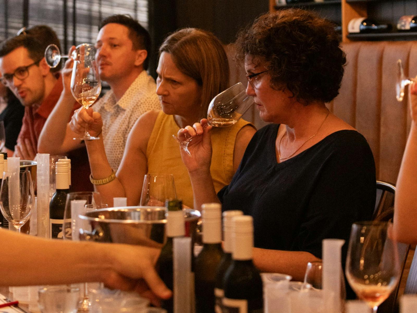 Group of people participating in a wine blend, smelling and tasting wine