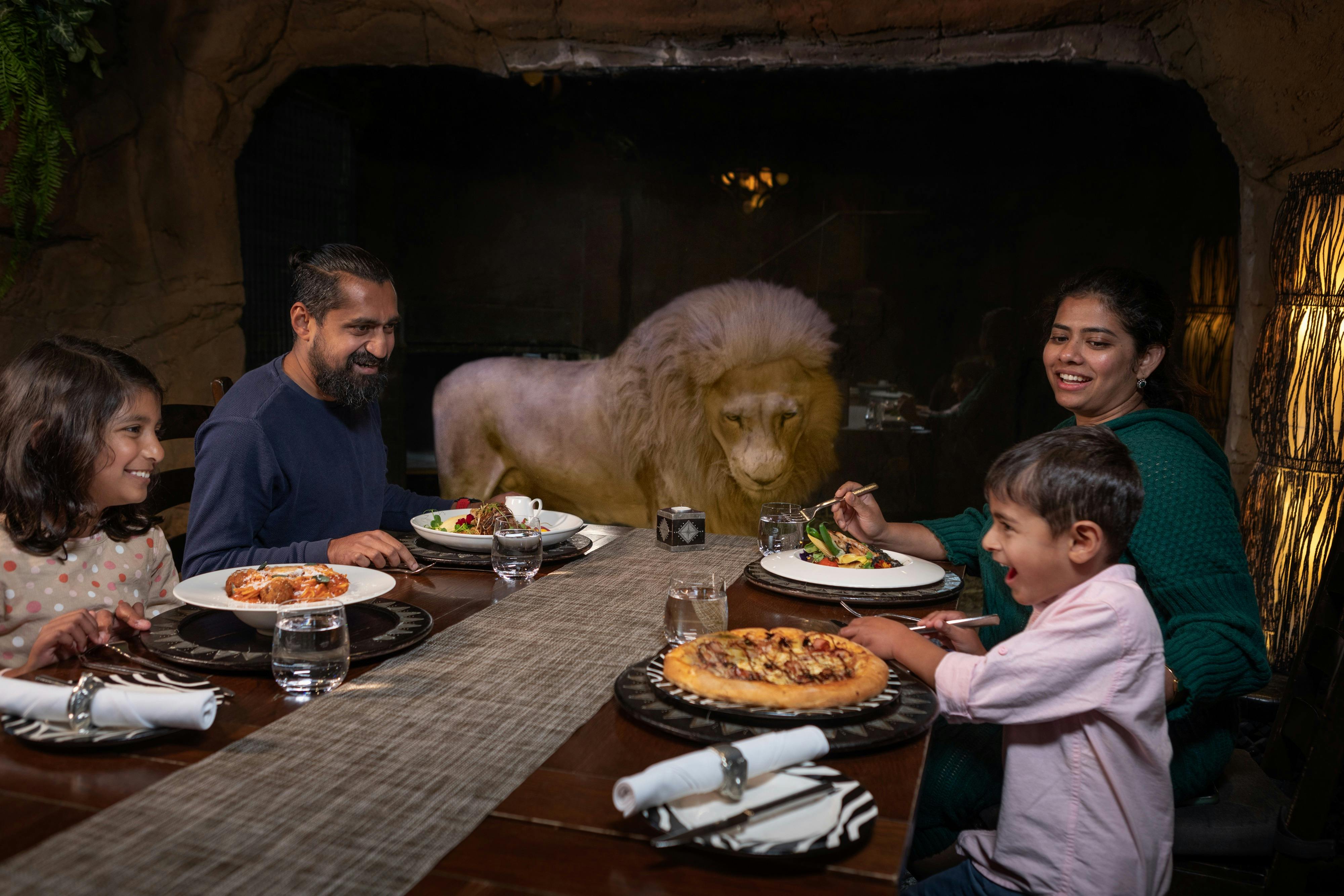 Family dining in Cave Restaurant with Jake the white lion.