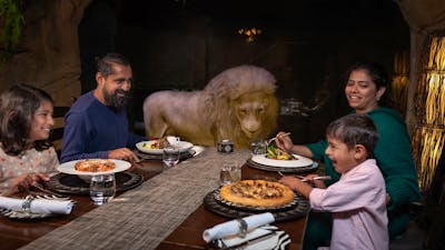 Family dining in Cave Restaurant with Jake the white lion.