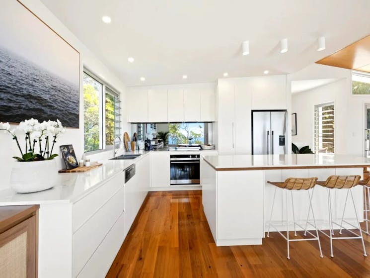 Sleek island kitchen boasting CaesarStone benchtops and top-of-the-line appliances