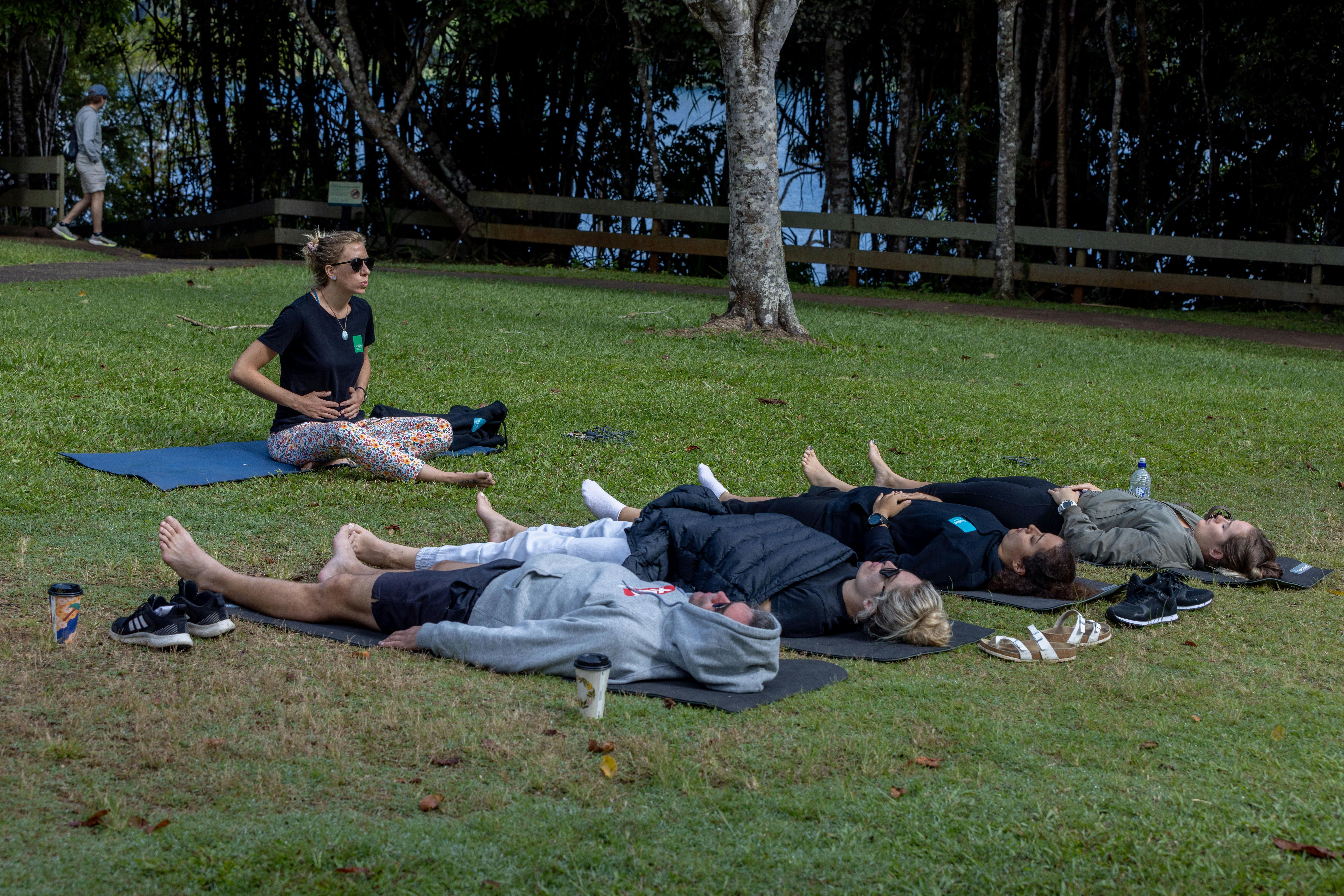 Group of divers are practicing holding their breath on the grass next to the lake