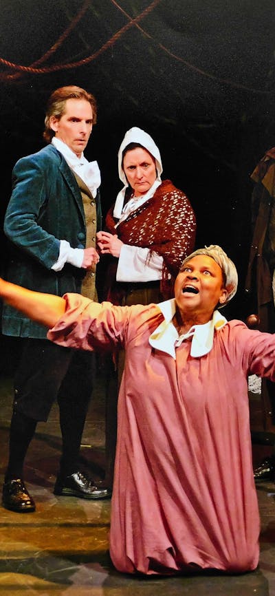 a young woman in pink dress is on her knees as 5 others in 1690s period costume look on in fear