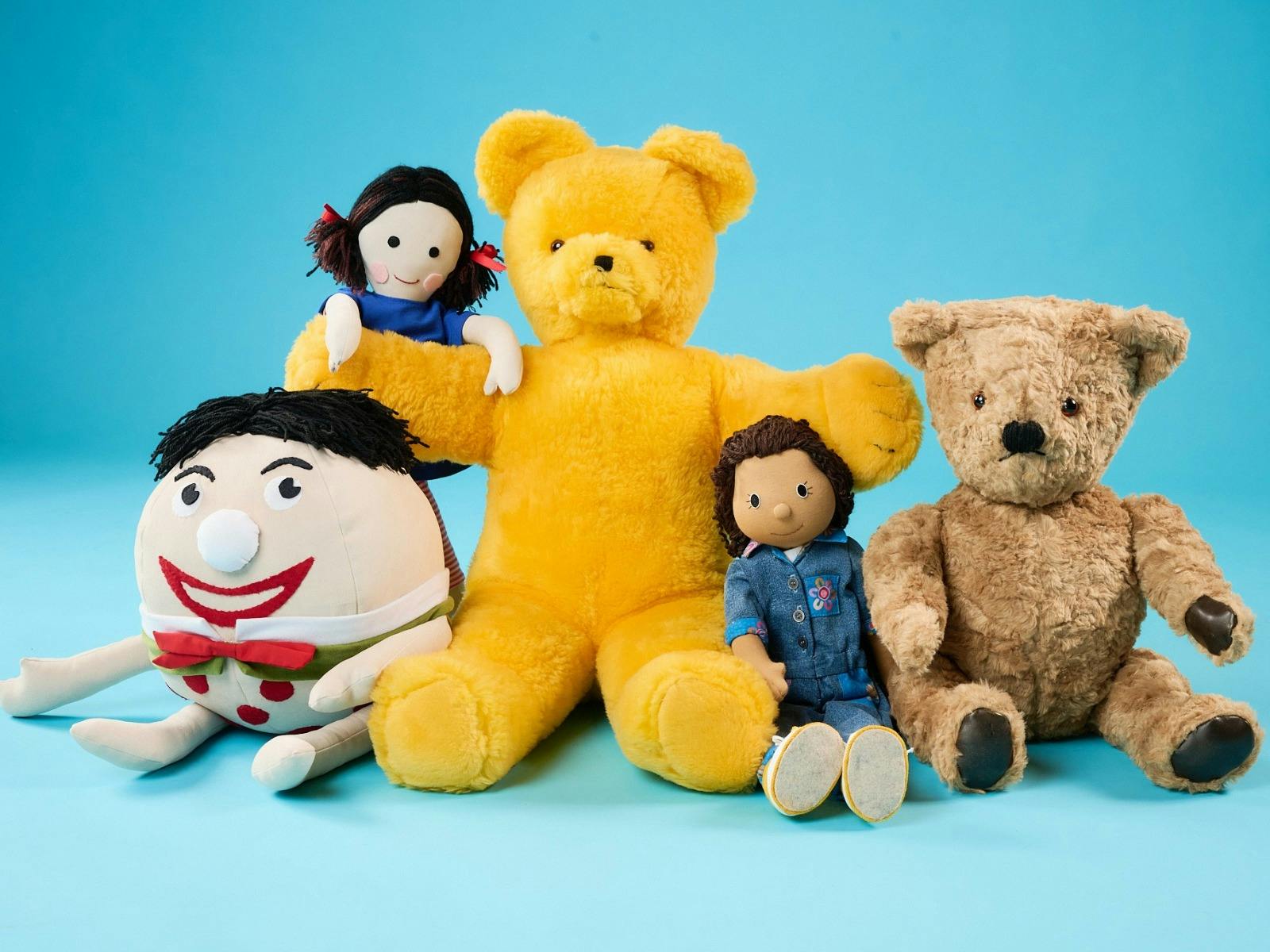 Collection of Play School  plush toys and dolls displayed against a blue background.