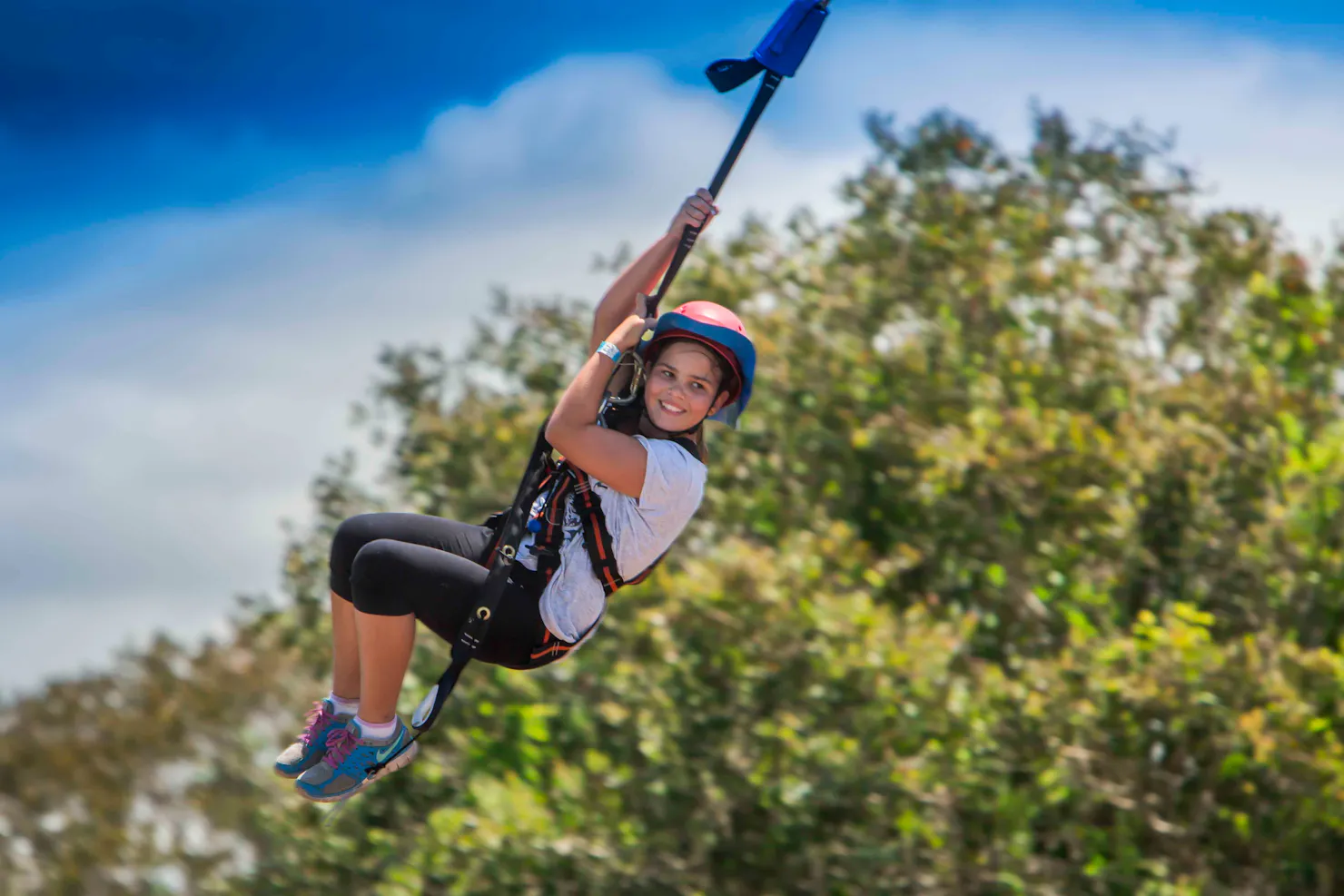 Girl, smiling while suspended on the Giant Swing at Sunshine Coast Recreation Precinct