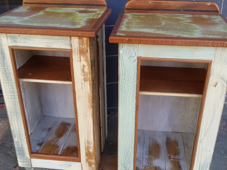 A pair of timber bedside tables with one shelf