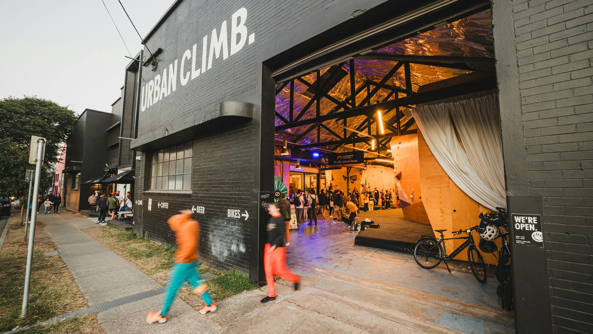 A black painted brick building, the facade of which says "Urban Climb." at the roller door entrance A black painted brick building, the facade of which says "Urban Climb." at the roller door entrance