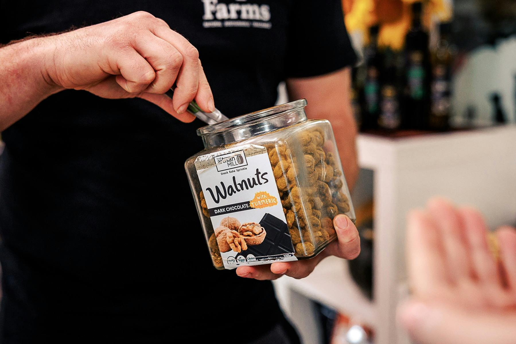 Staff offers a tasting of Pepo Farms’ popular dark chocolate turmeric walnuts in the farm shop.