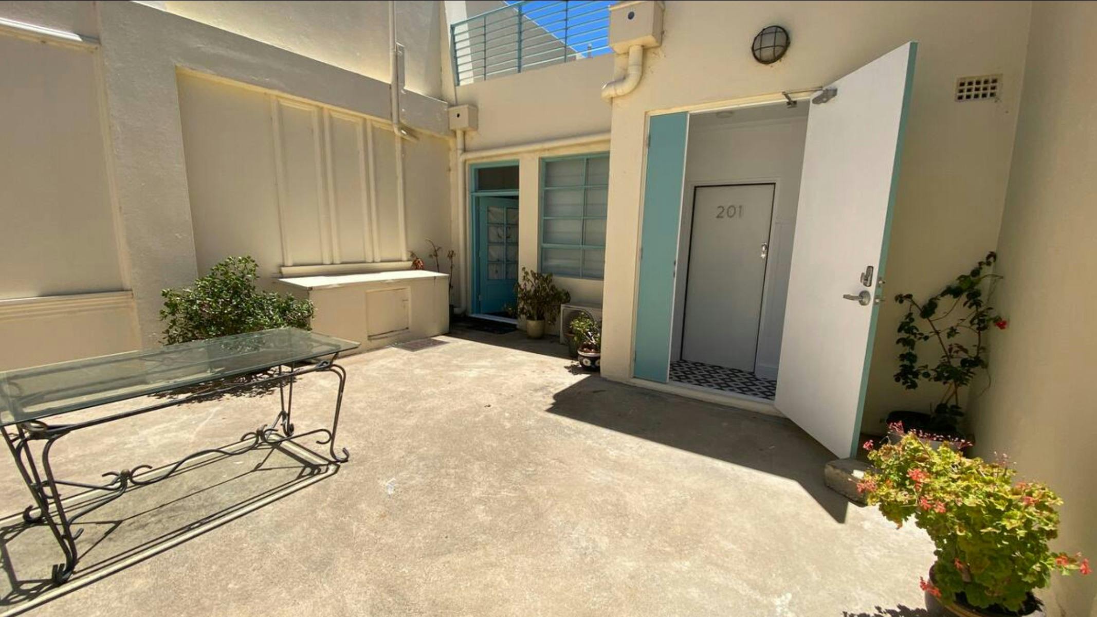 A rooftop with plants and doors leading onto it.