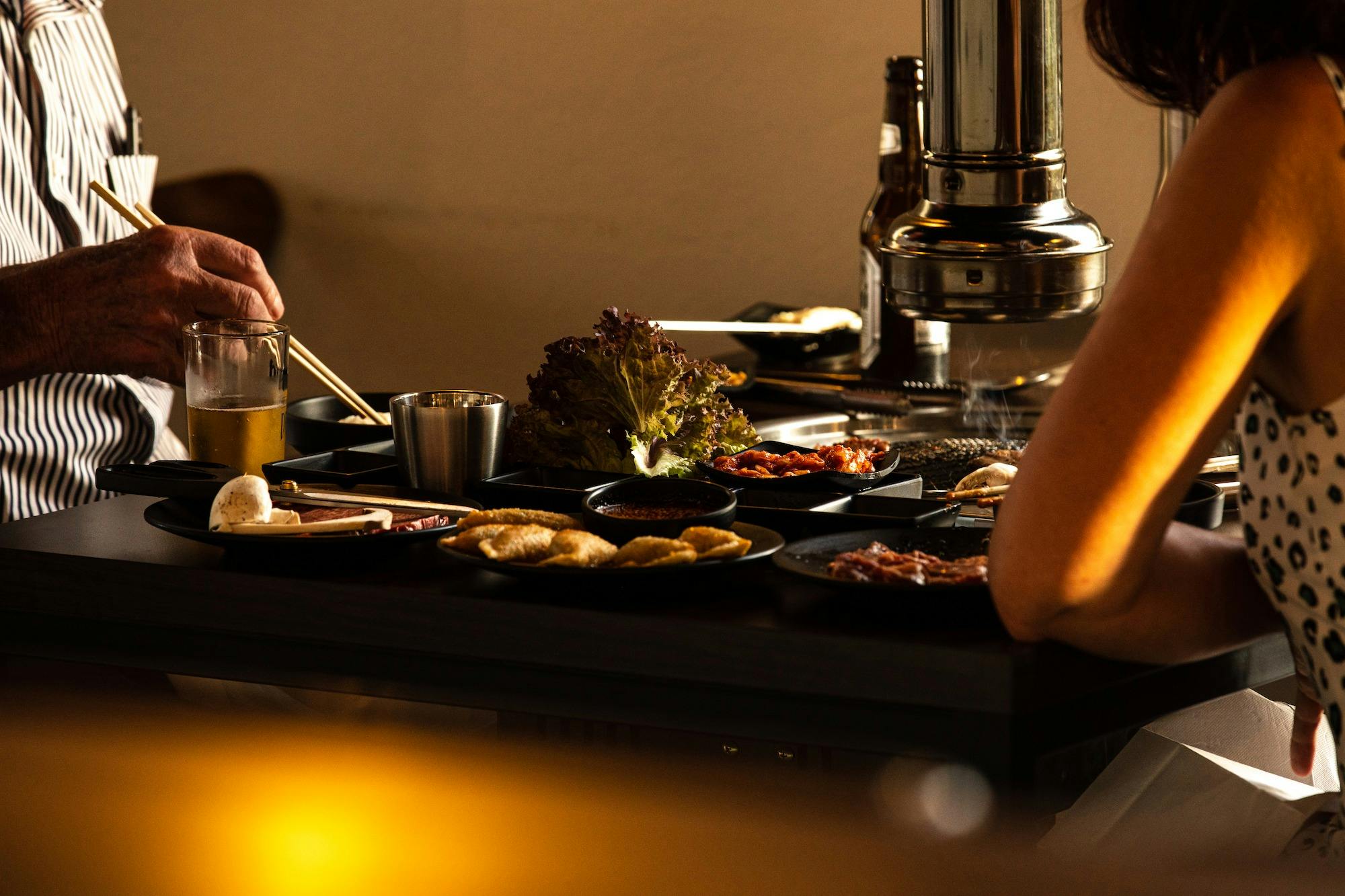 Two people of different generations enjoying Korean BBQ lunch at Jiggle.