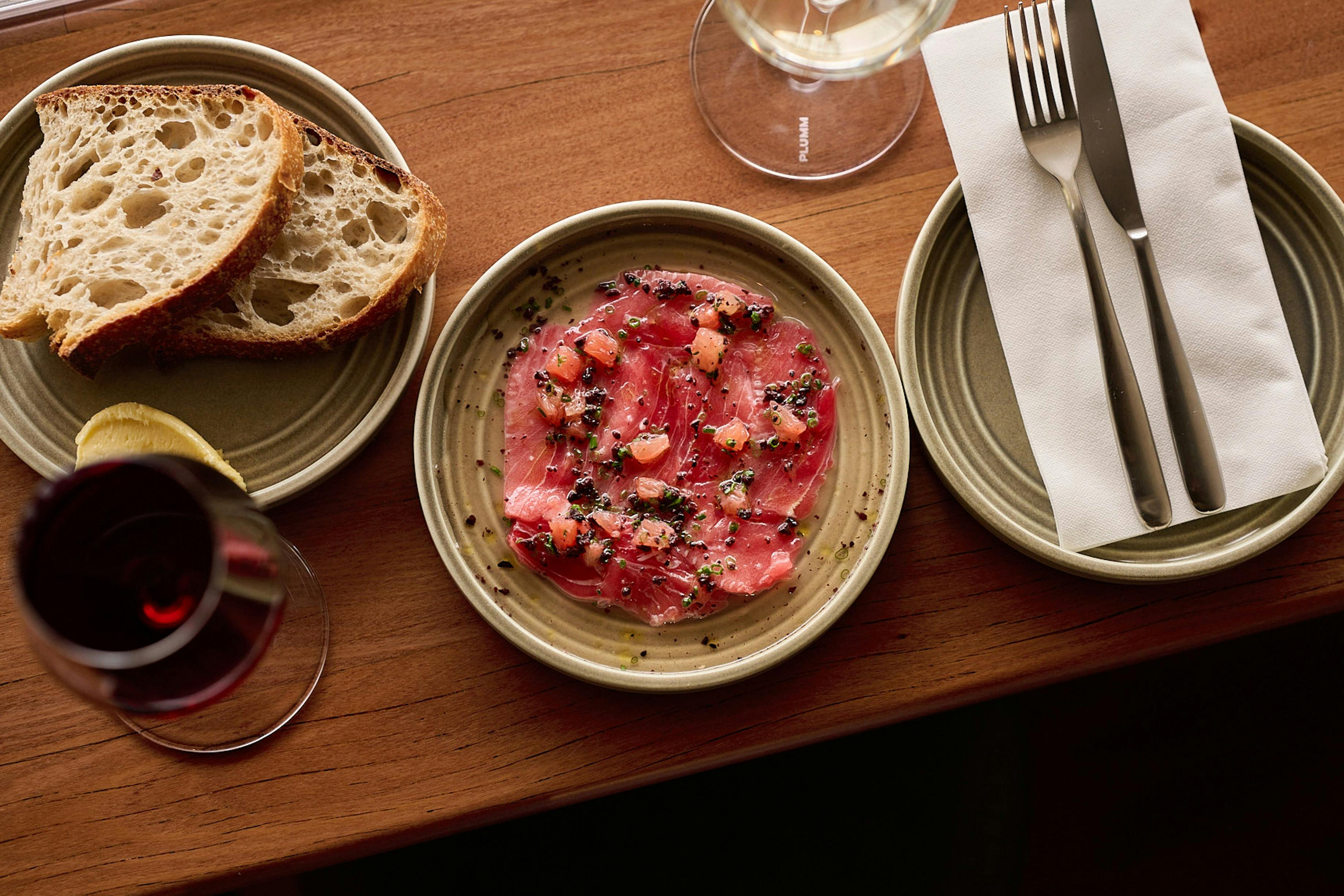 Market Fish Crudo served with a glass of white wine