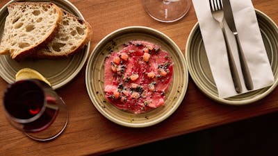 Market Fish Crudo served with a glass of white wine
