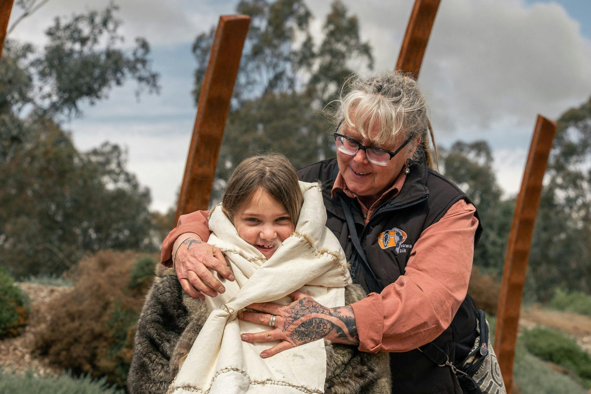 child trying a possum skin cloak
