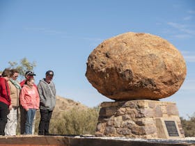 Family standing at John Flynn's resting site in Alice Springs